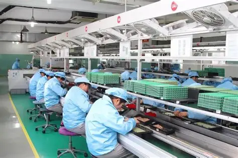 workers operating electronics assembly line in integrated manufacturing environment